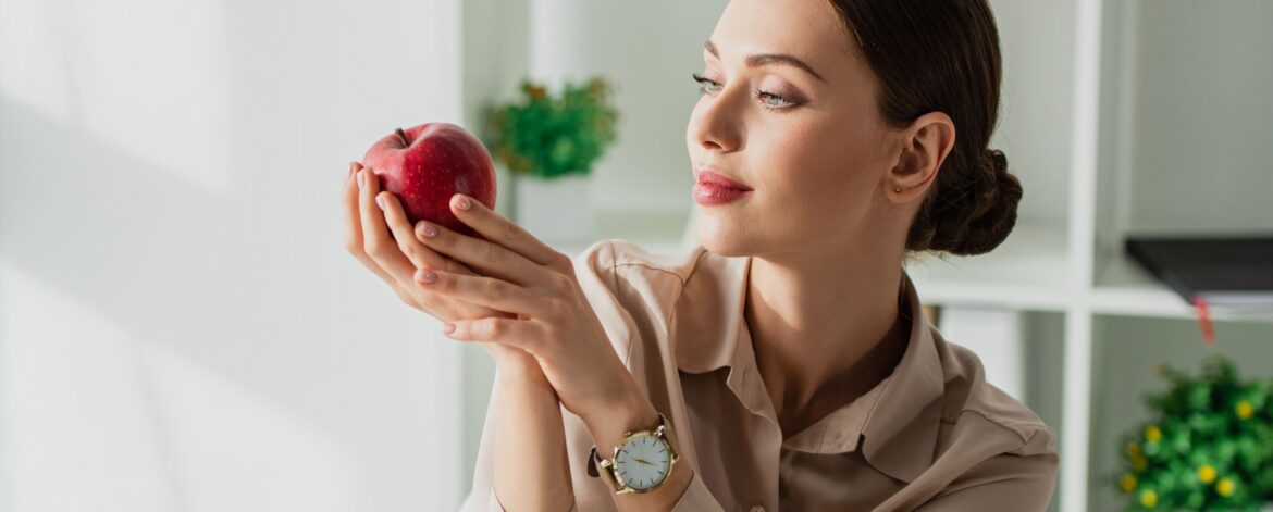 ragazza mangia frutta in ufficio