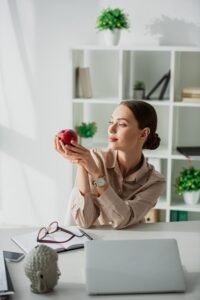 ragazza mangia frutta in ufficio