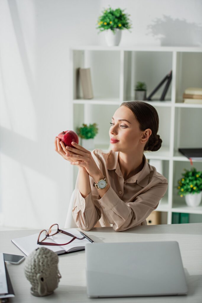 ragazza mangia frutta in ufficio